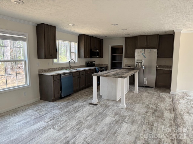 kitchen featuring crown molding, dark brown cabinetry, stainless steel appliances, light wood-style floors, and a textured ceiling