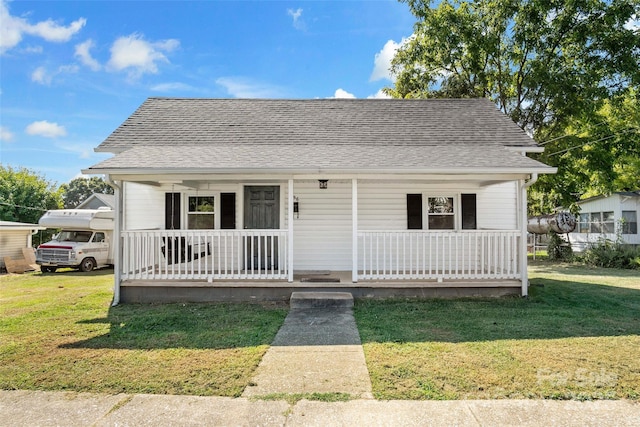 bungalow-style home featuring covered porch and a front lawn