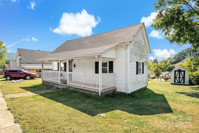 view of front of home featuring a porch, a storage shed, and a front lawn