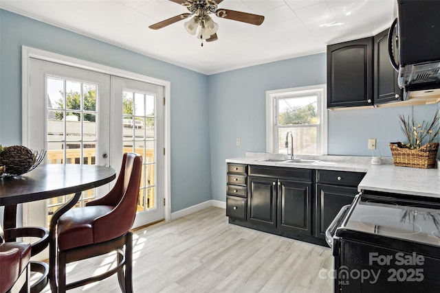 kitchen featuring french doors, sink, light wood-type flooring, ceiling fan, and black appliances