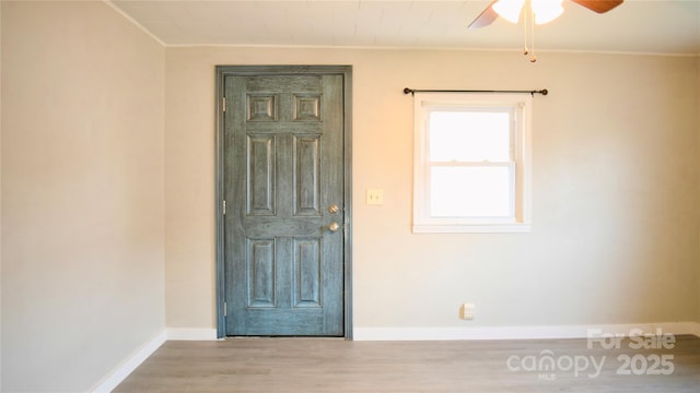 foyer with crown molding, ceiling fan, and light hardwood / wood-style floors