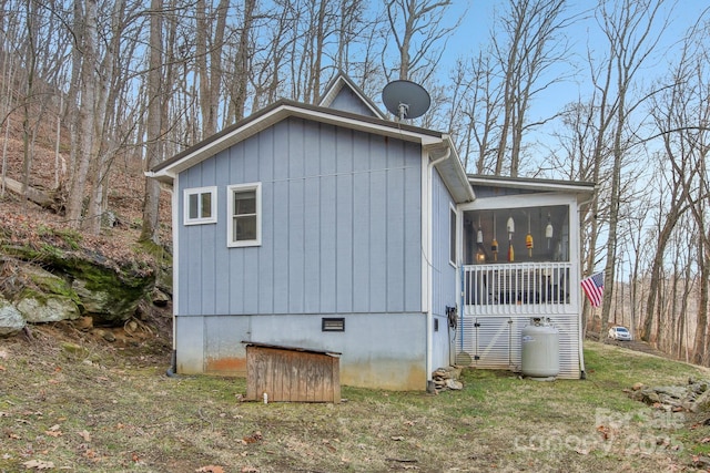 view of property exterior featuring a sunroom and a yard