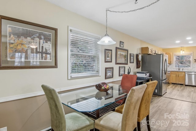 dining area with sink and light hardwood / wood-style floors