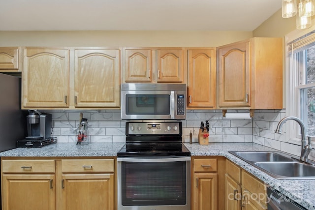 kitchen featuring light brown cabinetry, sink, decorative backsplash, and stainless steel appliances