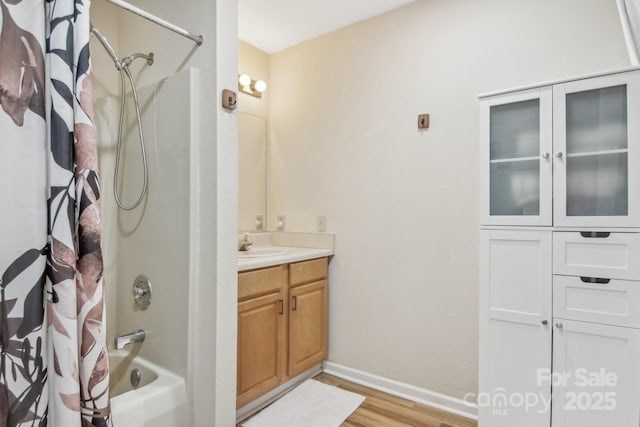 bathroom with hardwood / wood-style flooring, vanity, and shower / bath combo with shower curtain