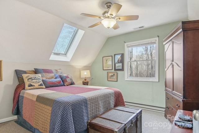 bedroom featuring vaulted ceiling with skylight, a baseboard heating unit, light carpet, and ceiling fan