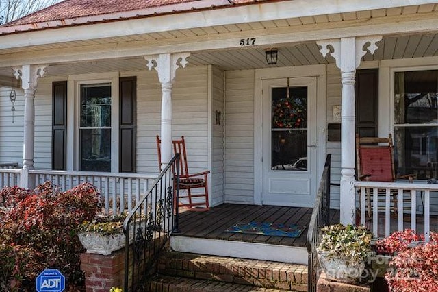 view of exterior entry featuring covered porch