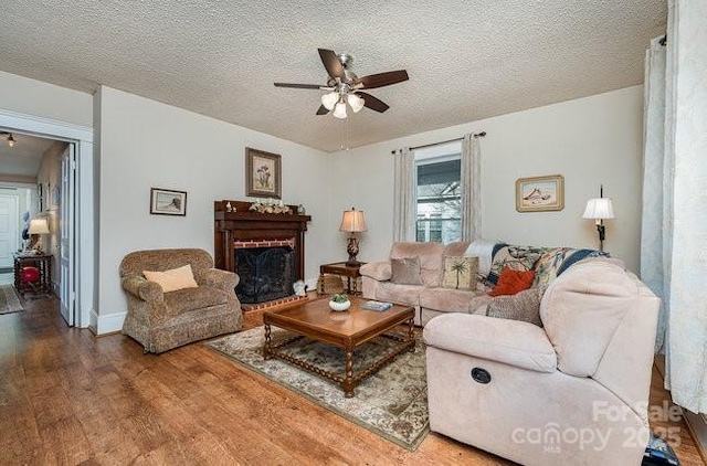 living room with ceiling fan, hardwood / wood-style floors, and a textured ceiling