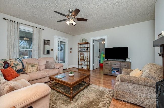 living room featuring hardwood / wood-style floors, a textured ceiling, and ceiling fan