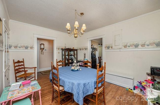 dining area with an inviting chandelier, wood-type flooring, and a textured ceiling