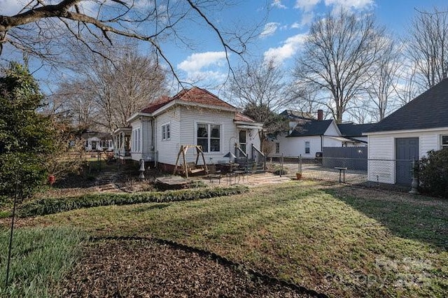 rear view of house featuring a yard