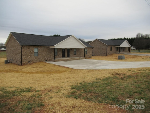 view of front facade with cooling unit, a front yard, and a patio