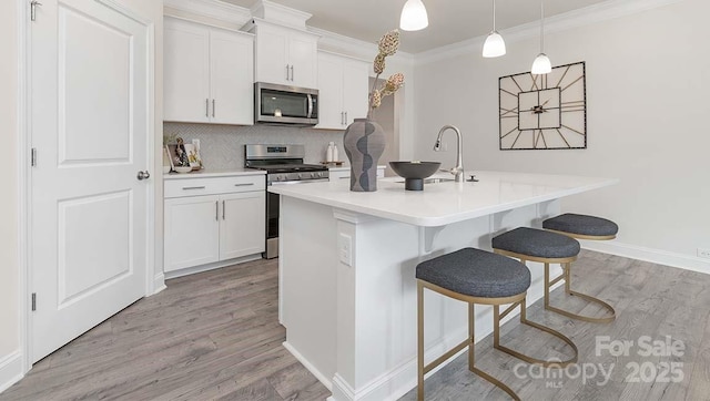 108 Sari St, Troutman, NC 28166 - kitchen with stainless steel appliances, light wood-type flooring, a kitchen bar, a kitchen island with sink, and white cabinets