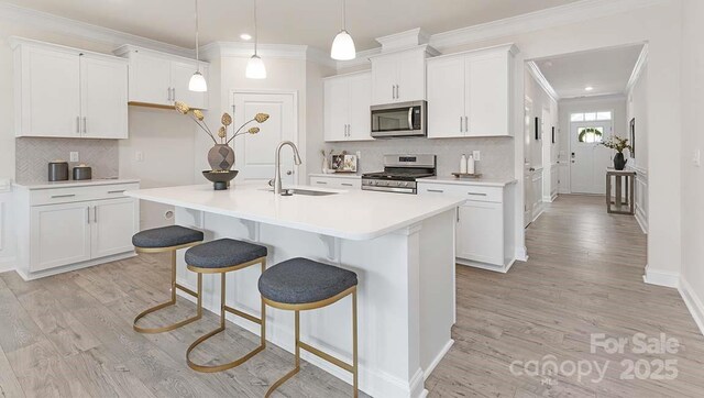108 Sari St, Troutman, NC 28166 - kitchen with appliances with stainless steel finishes, crown molding, light wood-style floors, decorative backsplash, and white cabinets