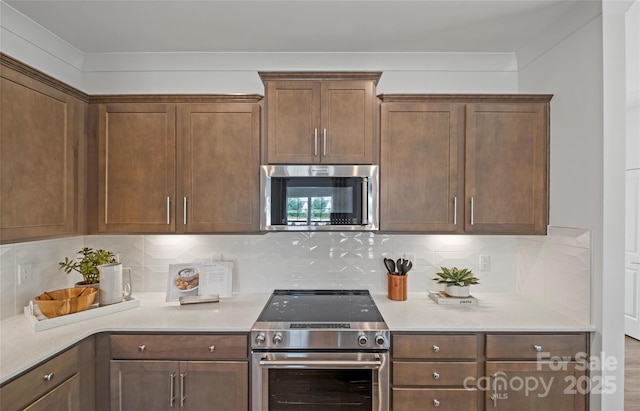 kitchen with backsplash and appliances with stainless steel finishes