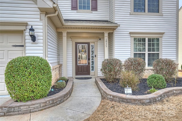 entrance to property featuring roof with shingles