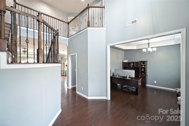 interior space with baseboards, visible vents, a chandelier, and wood finished floors