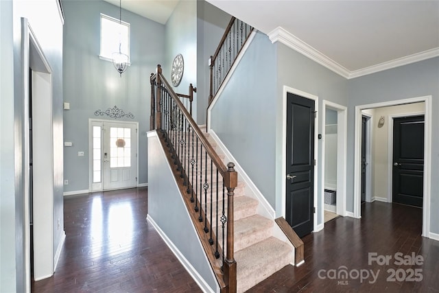 entrance foyer featuring stairway, crown molding, baseboards, and wood finished floors