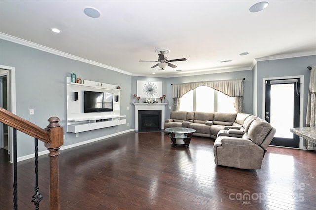 living room featuring a healthy amount of sunlight, crown molding, baseboards, and hardwood / wood-style floors