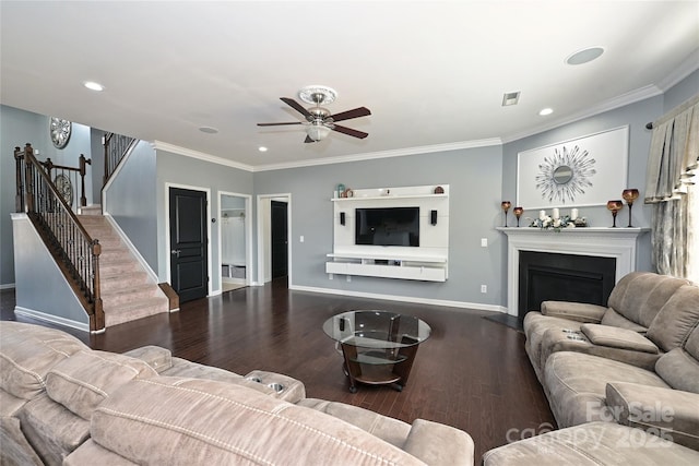 living area featuring baseboards, a glass covered fireplace, ornamental molding, wood finished floors, and stairs