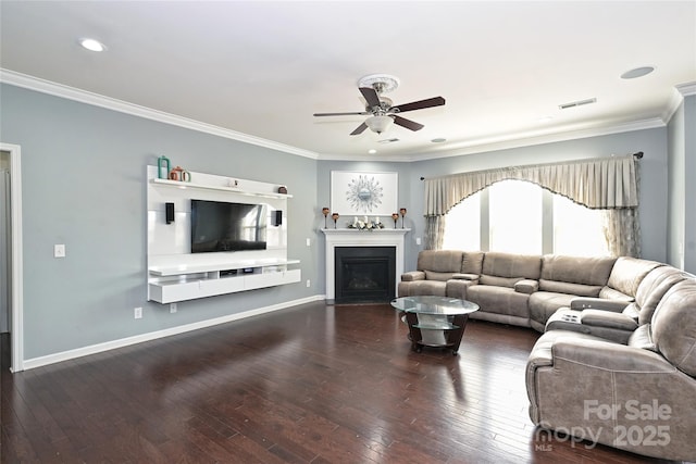 living area featuring hardwood / wood-style flooring, a fireplace, visible vents, baseboards, and ornamental molding