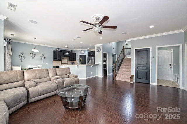 living area with visible vents, stairs, ornamental molding, and wood finished floors