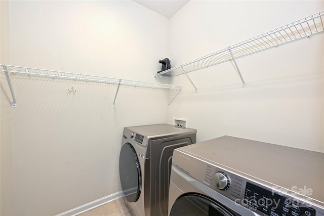 laundry room with laundry area, light tile patterned flooring, baseboards, and separate washer and dryer