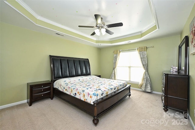 bedroom featuring light carpet, baseboards, and a raised ceiling