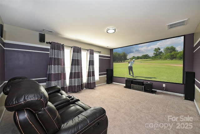 carpeted cinema room featuring visible vents and baseboards