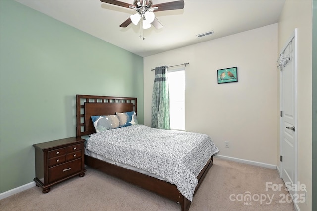 bedroom with baseboards, a ceiling fan, visible vents, and light colored carpet