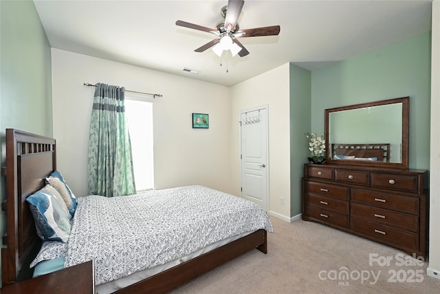 bedroom featuring light colored carpet, ceiling fan, visible vents, and baseboards