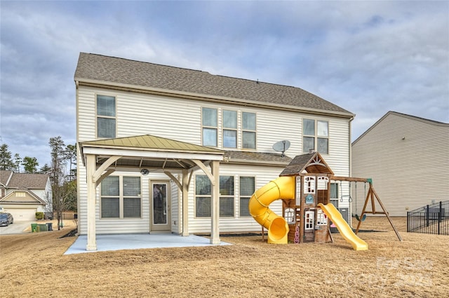 back of property with a patio area, a playground, a gazebo, and roof with shingles