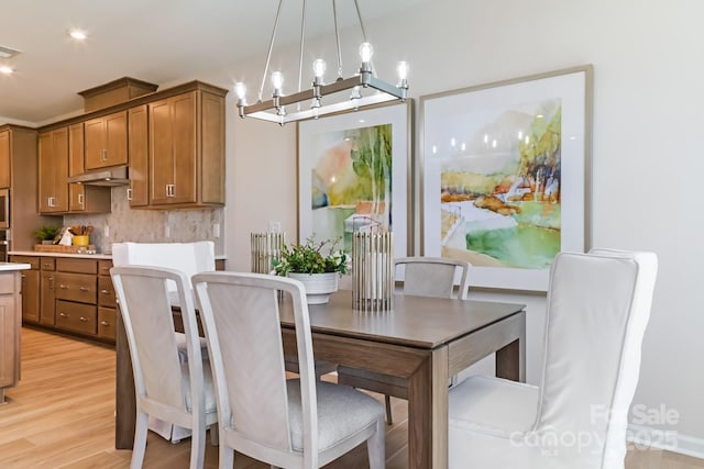 dining room featuring an inviting chandelier and light hardwood / wood-style flooring