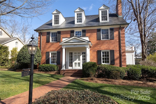 colonial-style house featuring a front yard