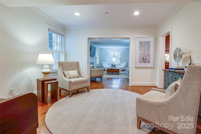 sitting room featuring crown molding, a wealth of natural light, and light wood-type flooring