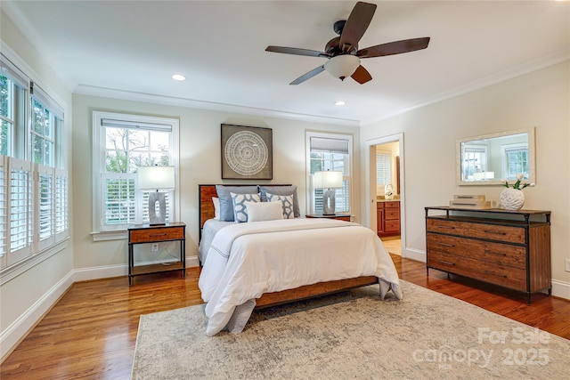 bedroom featuring dark hardwood / wood-style flooring, multiple windows, ornamental molding, and ceiling fan