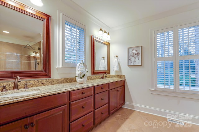 bathroom featuring tile patterned flooring, crown molding, and vanity