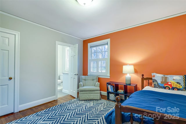 bedroom featuring hardwood / wood-style flooring, ensuite bathroom, and crown molding