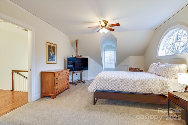 carpeted bedroom with ceiling fan, vaulted ceiling, and multiple windows