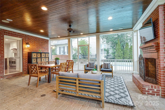 sunroom / solarium featuring an outdoor brick fireplace, wooden ceiling, and a healthy amount of sunlight