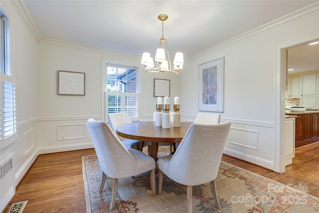 dining space with radiator, crown molding, and light hardwood / wood-style flooring