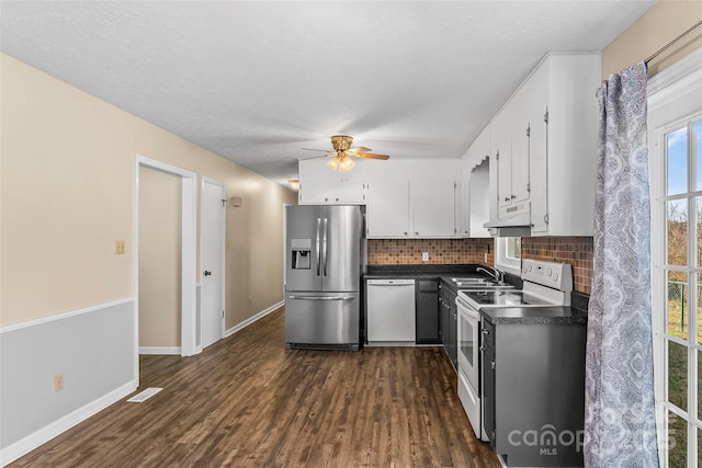 kitchen with white appliances, white cabinetry, dark hardwood / wood-style floors, and backsplash