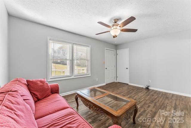 living room with a textured ceiling, ceiling fan, and wood-type flooring