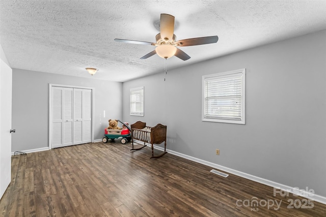 interior space featuring a textured ceiling, ceiling fan, and dark hardwood / wood-style floors