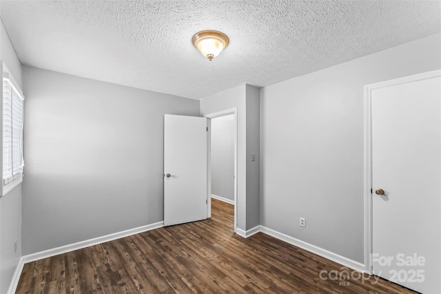 unfurnished bedroom featuring dark hardwood / wood-style flooring and a textured ceiling