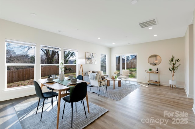 dining area with plenty of natural light and light hardwood / wood-style flooring