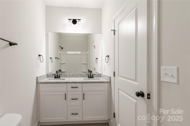 bathroom featuring vanity, toilet, and walk in shower