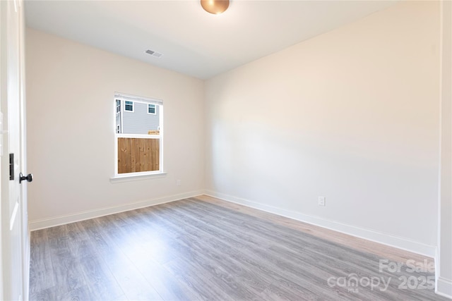 unfurnished room with wood-type flooring