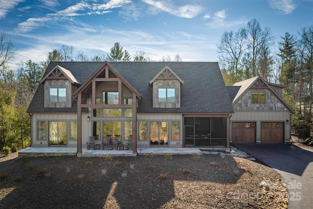 view of front of property featuring a sunroom, a patio, and a garage