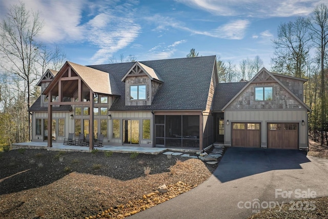 view of front of property with a garage, a patio area, and a sunroom